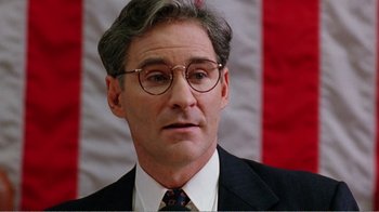 Movie still from “Dave” (1993), directed by Ivan Reitman – A person wearing a suit and glasses; Close Up shot, Low angle