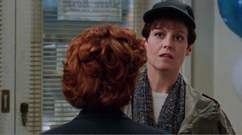 Movie still from “Dave” (1993), directed by Ivan Reitman – A woman in a hat and scarf looking at another woman in front of a window; Close Up shot, Over the shoulder angle