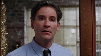 Movie still from “Dave” (1993), directed by Ivan Reitman – A man in a blue dress shirt and a tie; Close Up shot, Over the shoulder angle