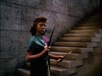 Movie still from “David and Bathsheba” (1951), directed by Henry King – A man holding a sword in front of a stone wall; Medium shot, High angle
