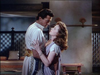 Movie still from “David and Bathsheba” (1951), directed by Henry King – A man and a woman are embracing in a room; Medium shot, Low angle