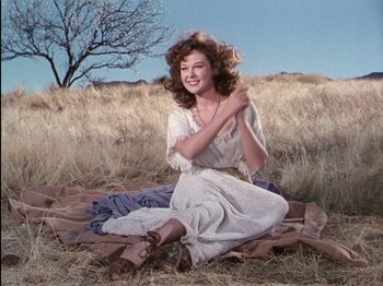Movie still from “David and Bathsheba” (1951), directed by Henry King – A woman sitting on a blanket in a field; Medium shot, Low angle