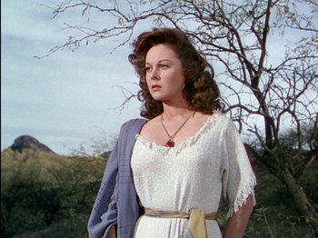Movie still from “David and Bathsheba” (1951), directed by Henry King – A woman in a white dress standing next to a tree; Medium shot, Low angle