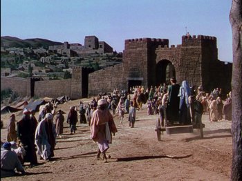Movie still from “David and Bathsheba” (1951), directed by Henry King – A group of people walking in a dirt field; Extreme Wide shot, High angle