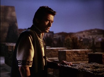 Movie still from “David and Bathsheba” (1951), directed by Henry King – A man standing on top of a building near a wall; Medium shot, Low angle