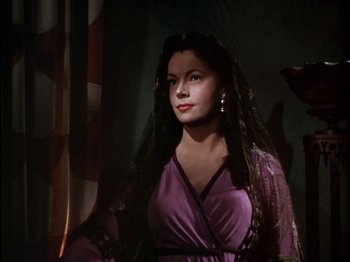 Movie still from “David and Bathsheba” (1951), directed by Henry King – A woman wearing a purple dress and a veil; Medium shot, Low angle