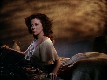 Movie still from “David and Bathsheba” (1951), directed by Henry King – A woman laying on the ground in a room; Medium shot, Low angle