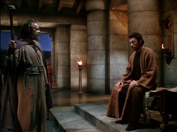 Movie still from “David and Bathsheba” (1951), directed by Henry King – A man in brown robe sitting on steps next to another man in brown robe; Wide shot, High angle