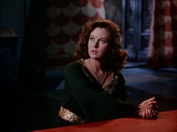 Movie still from “David and Bathsheba” (1951), directed by Henry King – A woman sitting at a table in front of a window; Medium shot, High angle