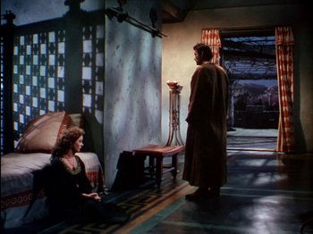 Movie still from “David and Bathsheba” (1951), directed by Henry King – A man and a woman standing in front of a fireplace; Wide shot, High angle