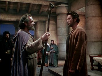 Movie still from “David and Bathsheba” (1951), directed by Henry King – Two men are standing in front of a stone building; Medium shot, Over the shoulder angle