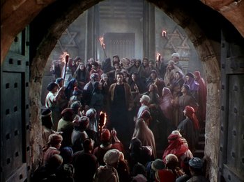 Movie still from “David and Bathsheba” (1951), directed by Henry King – A group of people gathered in a building with torches; Wide shot, High angle