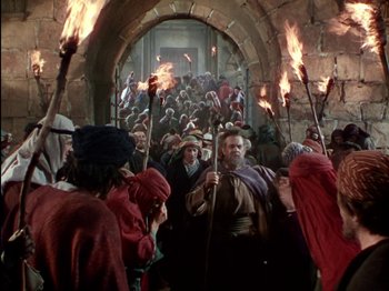Movie still from “David and Bathsheba” (1951), directed by Henry King – A group of people holding torches in front of a crowd; Wide shot, High angle