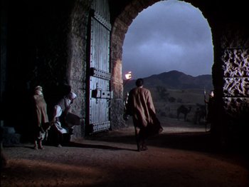 Movie still from “David and Bathsheba” (1951), directed by Henry King – A group of people standing in front of an arched doorway; Wide shot, Low angle