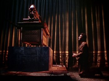 Movie still from “David and Bathsheba” (1951), directed by Henry King – A man kneeling down in front of an alter; Wide shot, Low angle