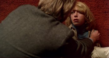 Movie still from “Dawn of the Dead” (1978), directed by George A. Romero – A woman sitting on the ground looking into a mirror; Close Up shot, Overhead angle