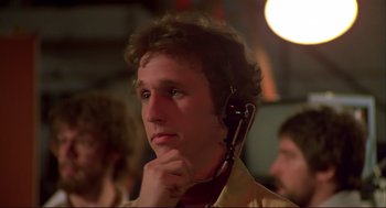 Movie still from “Dawn of the Dead” (1978), directed by George A. Romero – A man with a headset on looking at the camera; Close Up shot, Low angle