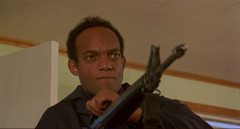 Movie still from “Dawn of the Dead” (1978), directed by George A. Romero – A man holding a gun in a room; Close Up shot, Low angle