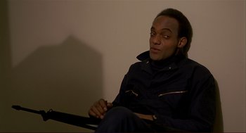 Movie still from “Dawn of the Dead” (1978), directed by George A. Romero – A man sitting on a chair in a dark room; Close Up shot, High angle
