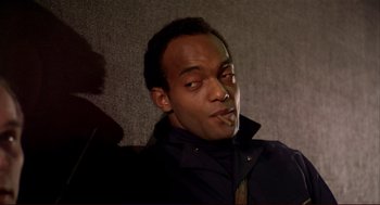 Movie still from “Dawn of the Dead” (1978), directed by George A. Romero – A man sitting on a wall smoking a cigarette; Close Up shot, Low angle