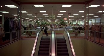 Movie still from “Dawn of the Dead” (1978), directed by George A. Romero – An escalator in a department store with a man on it; Extreme Wide shot, High angle