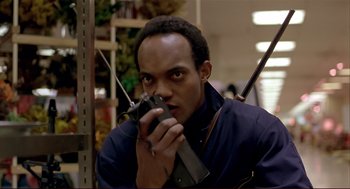 Movie still from “Dawn of the Dead” (1978), directed by George A. Romero – A man holding a gun in a store; Close Up shot, Low angle