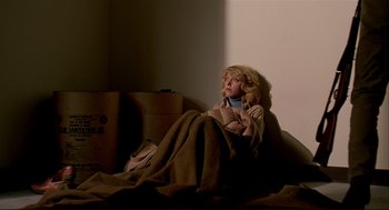 Movie still from “Dawn of the Dead” (1978), directed by George A. Romero – A woman wrapped in a blanket sitting on the floor; Wide shot, High angle