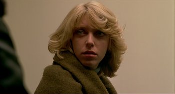 Movie still from “Dawn of the Dead” (1978), directed by George A. Romero – A woman with blonde hair wearing a green scarf; Close Up shot, Low angle