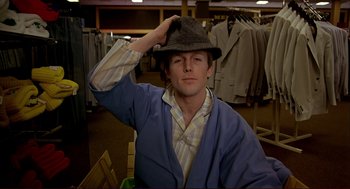 Movie still from “Dawn of the Dead” (1978), directed by George A. Romero – A young man in a store putting on a hat; Close Up shot, High angle