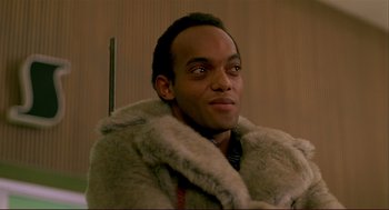 Movie still from “Dawn of the Dead” (1978), directed by George A. Romero – A man wearing a fur coat and a black shirt; Close Up shot, Low angle