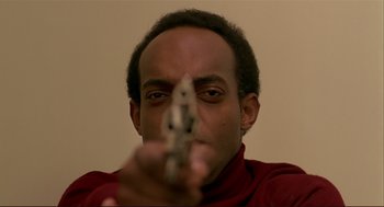 Movie still from “Dawn of the Dead” (1978), directed by George A. Romero – A man holding a gun pointed at the camera; Close Up shot, Low angle