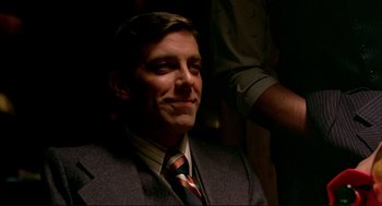 Movie still from “Dawn of the Dead” (1978), directed by George A. Romero – A person wearing a suit and a tie; Close Up shot, Over the shoulder angle