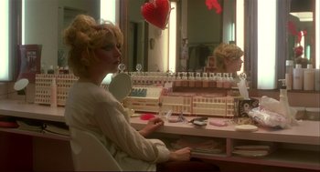 Movie still from “Dawn of the Dead” (1978), directed by George A. Romero – A woman sitting in front of a mirror holding a mirror; Medium shot, High angle