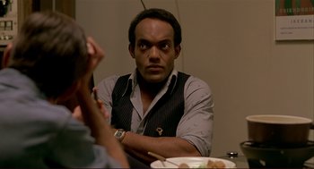 Movie still from “Dawn of the Dead” (1978), directed by George A. Romero – A man sitting in front of a plate of food; Close Up shot, Over the shoulder angle