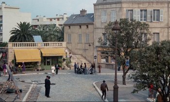 Movie still from “Day for Night” (1973), directed by François Truffaut – A group of people standing on a street corner; Extreme Wide shot, High angle