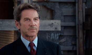 Movie still from “Day for Night” (1973), directed by François Truffaut – An older man in a suit and red tie; Close Up shot, Low angle