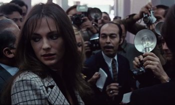 Movie still from “Day for Night” (1973), directed by François Truffaut – A group of people gathered around a woman in front of a camera; Medium shot, Over the shoulder angle