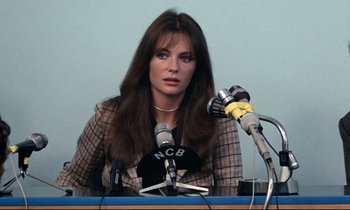 Movie still from “Day for Night” (1973), directed by François Truffaut – A woman sitting in front of microphones at a press conference; Close Up shot, Over the shoulder angle