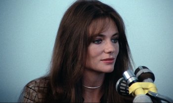 Movie still from “Day for Night” (1973), directed by François Truffaut – A person sitting at a microphone; Close Up shot, Over the shoulder angle