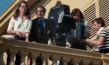 Movie still from “Day for Night” (1973), directed by François Truffaut – A group of people standing on top of a building; Medium shot, Low angle