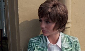 Movie still from “Day for Night” (1973), directed by François Truffaut – A woman with short brown hair wearing a green jacket; Close Up shot, High angle