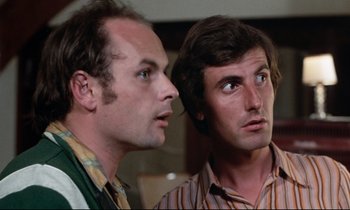 Movie still from “Day for Night” (1973), directed by François Truffaut – A couple of men standing next to each other; Close Up shot, Low angle