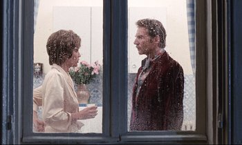 Movie still from “Day for Night” (1973), directed by François Truffaut – A man and a woman standing in front of a window; Medium shot, Over the shoulder angle