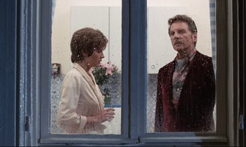 Movie still from “Day for Night” (1973), directed by François Truffaut – A man and a woman standing in front of a window; Medium shot, Over the shoulder angle