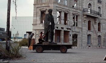 Movie still from “Day for Night” (1973), directed by François Truffaut – Two men in the back of a pick - up truck with a statue in the back of the truck; Wide shot, Low angle