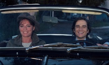 Movie still from “Day for Night” (1973), directed by François Truffaut – A man and a woman sitting in the back seat of a car; Medium shot, High angle