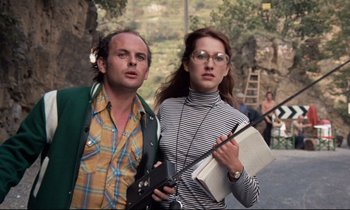 Movie still from “Day for Night” (1973), directed by François Truffaut – A man and a woman standing next to each other; Medium shot, Low angle