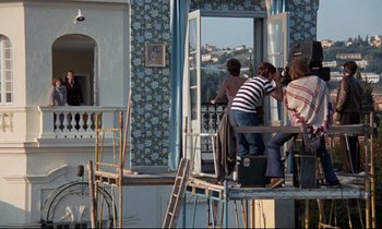 Movie still from “Day for Night” (1973), directed by François Truffaut – A group of people standing on a balcony; Extreme Wide shot, Low angle