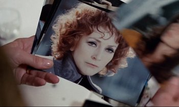 Movie still from “Day for Night” (1973), directed by François Truffaut – A person holding a picture of a woman with curly hair; Extreme Close Up shot, Over the shoulder angle
