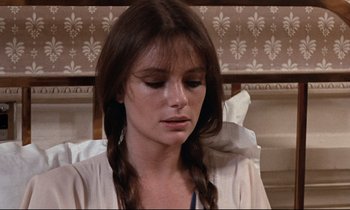 Movie still from “Day for Night” (1973), directed by François Truffaut – A woman with long brown plaits sitting in a bed; Close Up shot, Over the shoulder angle